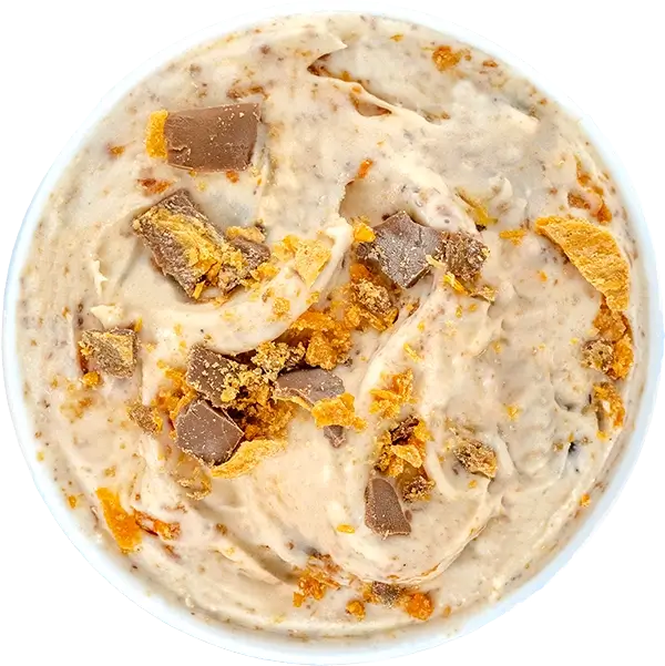 Creamy ice cream with chocolate and caramel chunks in a bowl. Delicious dessert topped with crunchy pieces.