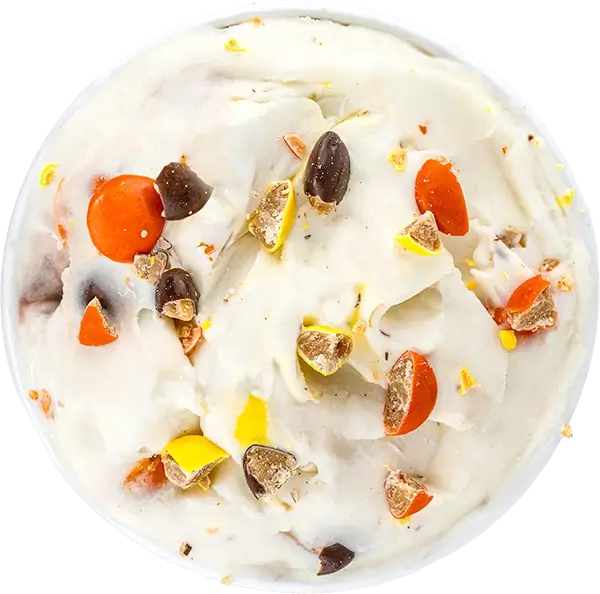 Delicious creamy ice cream topped with colorful candy pieces and chocolate chunks. Perfect sweet treat for dessert lovers.