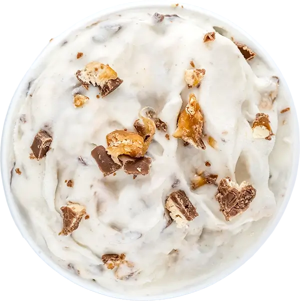 Creamy vanilla ice cream topped with chopped chocolate and caramel bits in a bowl. Perfect dessert treat.